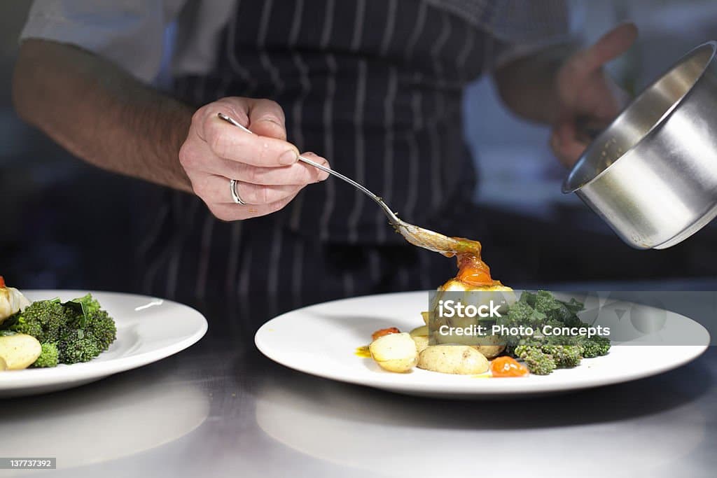 Chef plating a dish during professional food service.